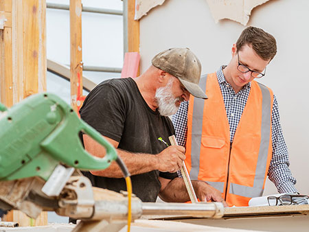 Builder and assessors examining a house floor plan