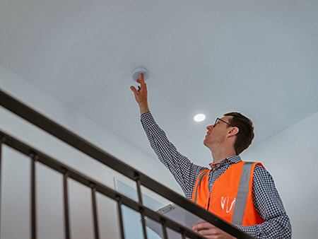 Assessor checking a smoke alarm device